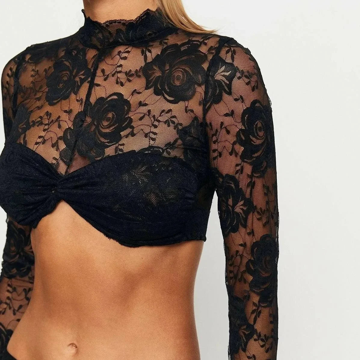 Sheer black lace crop top with floral design.