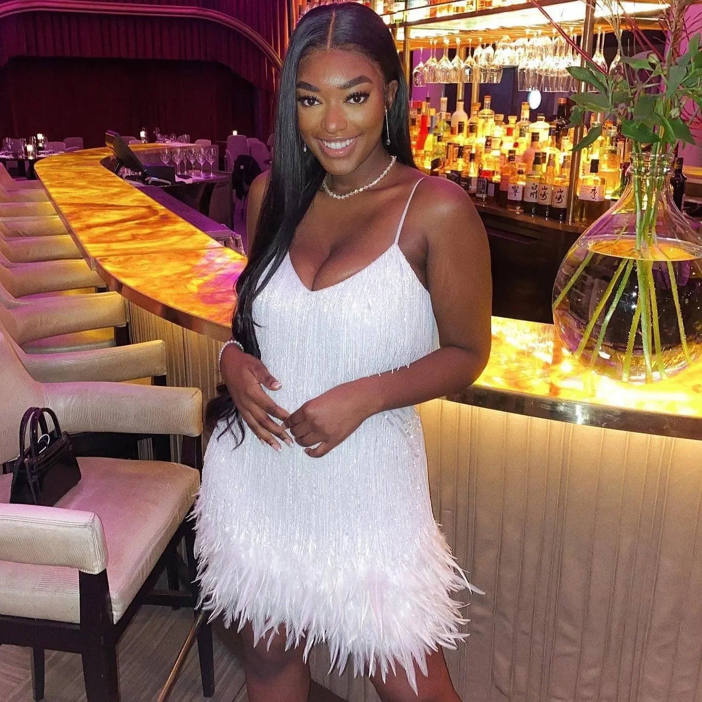 Feather-trimmed sequin mini dress with spaghetti straps, glamorous party outfit.