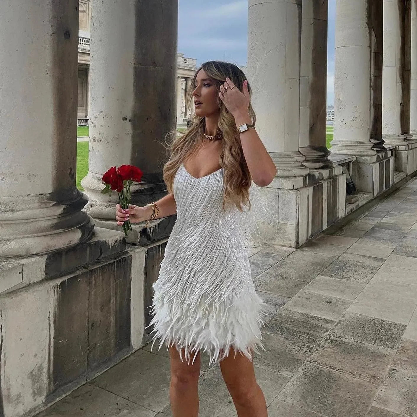 Feathered mini dress with embellishments, elegant party attire.
