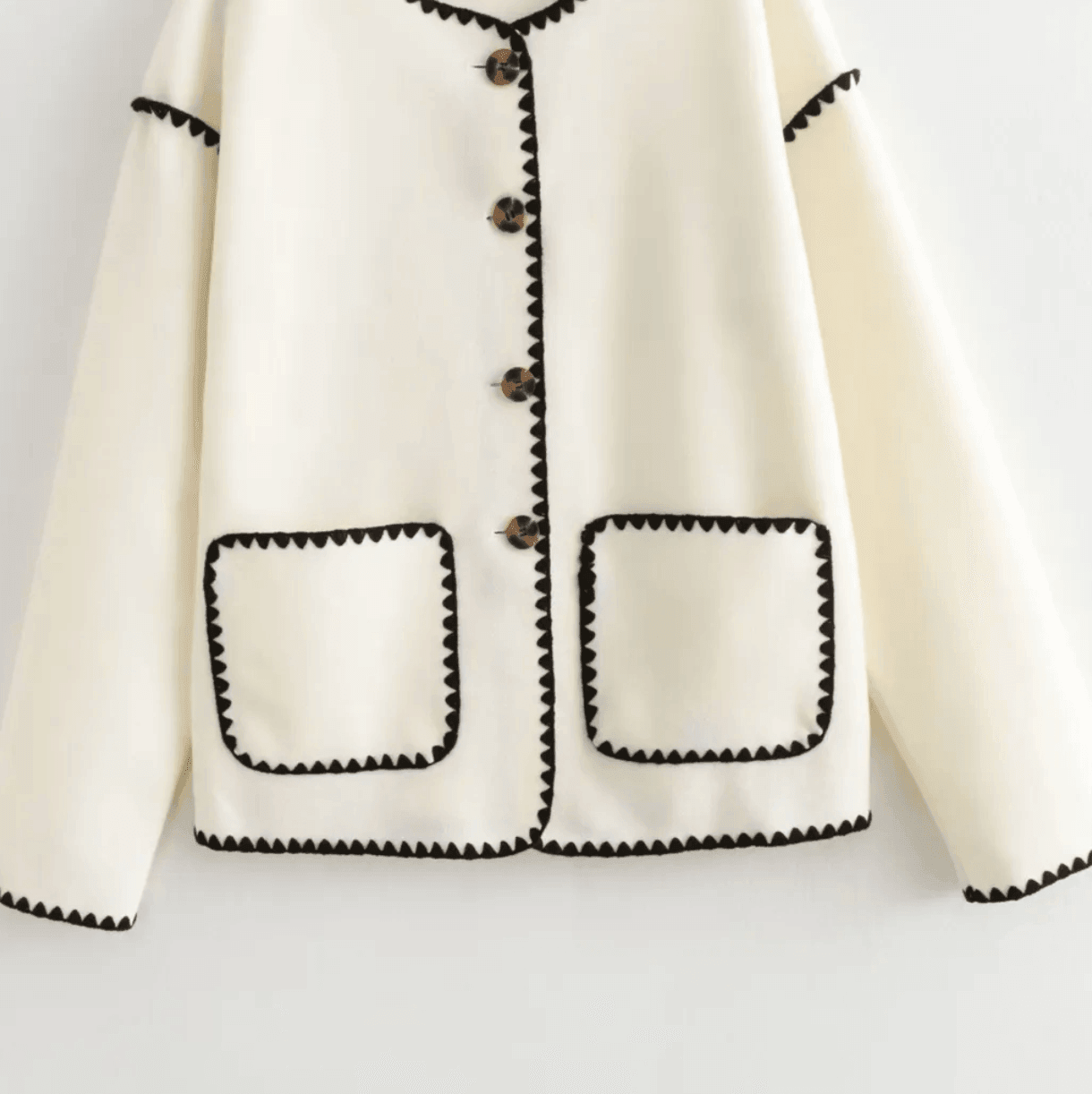Cream jacket with black scalloped trim and buttons, casual layering piece