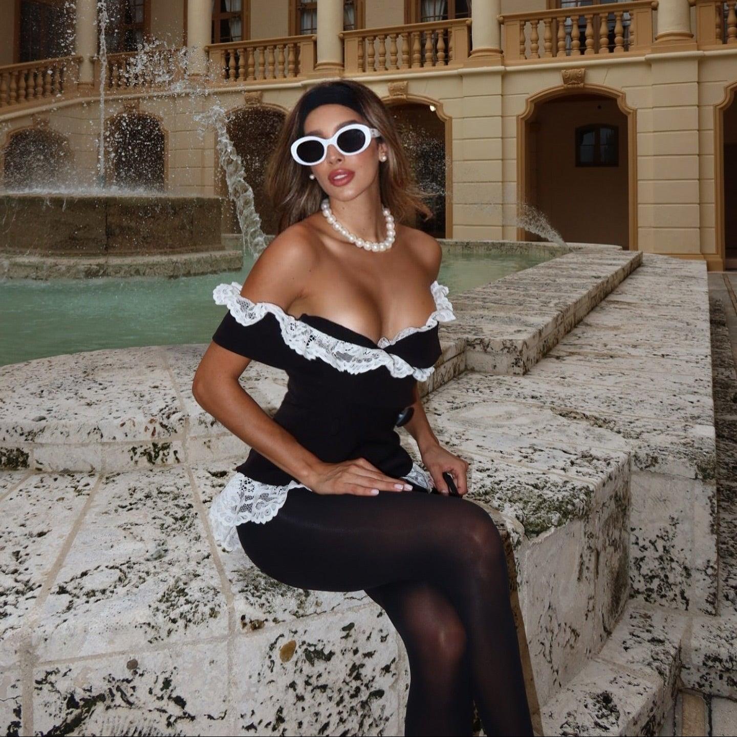 Off-the-shoulder black mini dress with white lace trim, elegant evening look