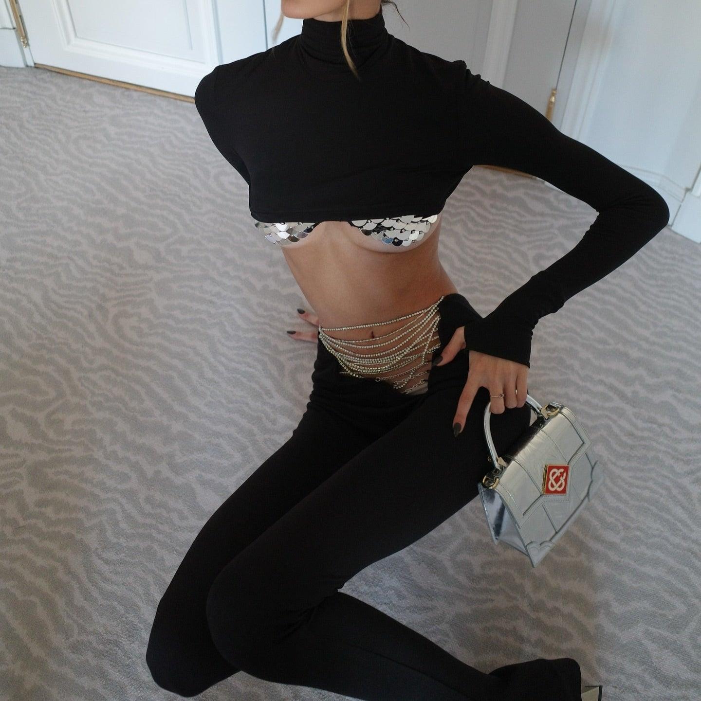 High-neck cropped top with long sleeves and sequin detailing, paired with chain belt and mini