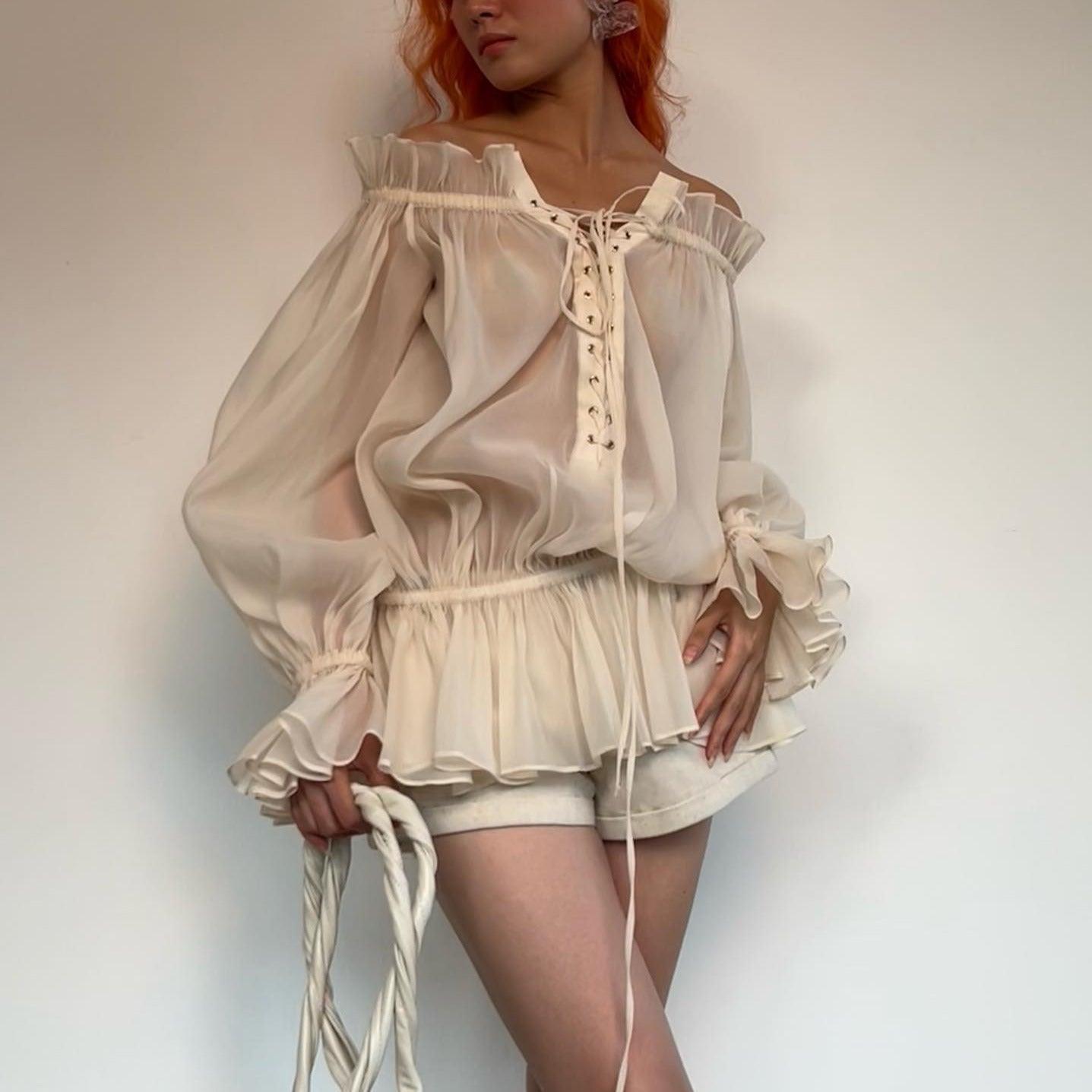 Sheer ruffled off-shoulder blouse with lace-up detail, stylish daywear top.