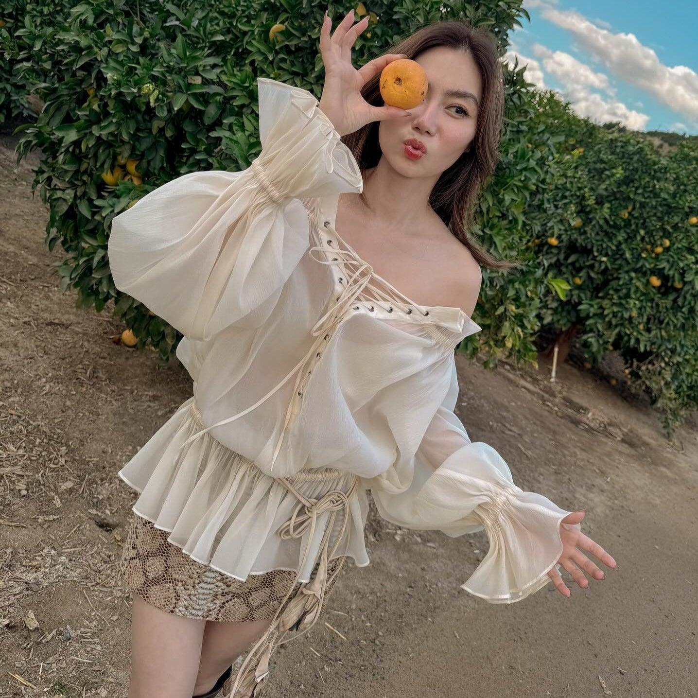 Sheer lace-up off-shoulder top with balloon sleeves, paired with snake print mini skirt, boho-chic