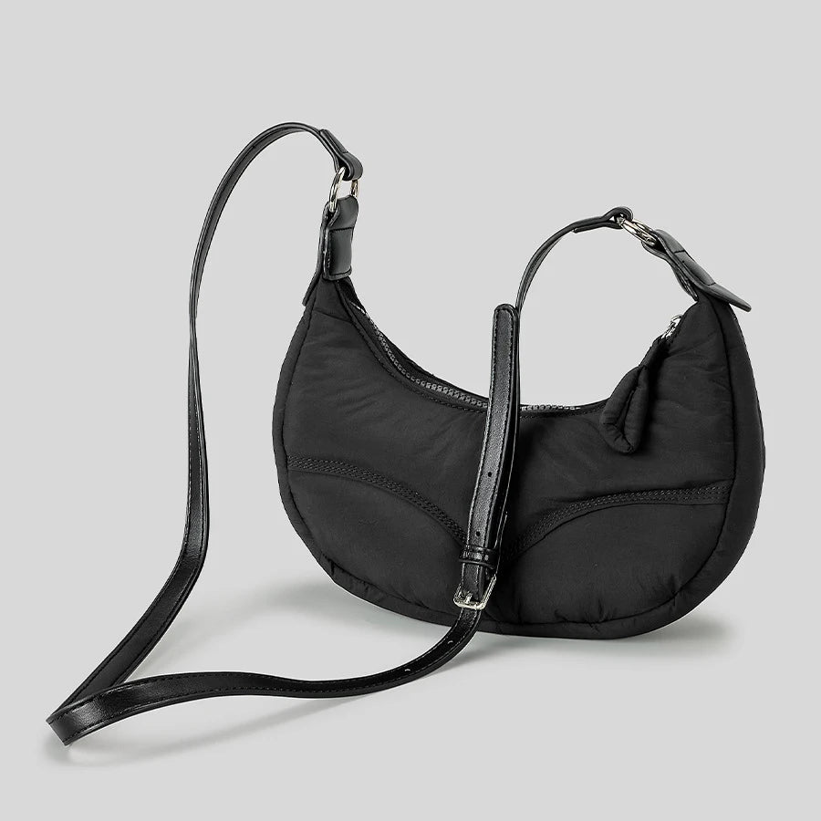 Black crescent-shaped shoulder bag with adjustable strap, versatile accessory for day or night.