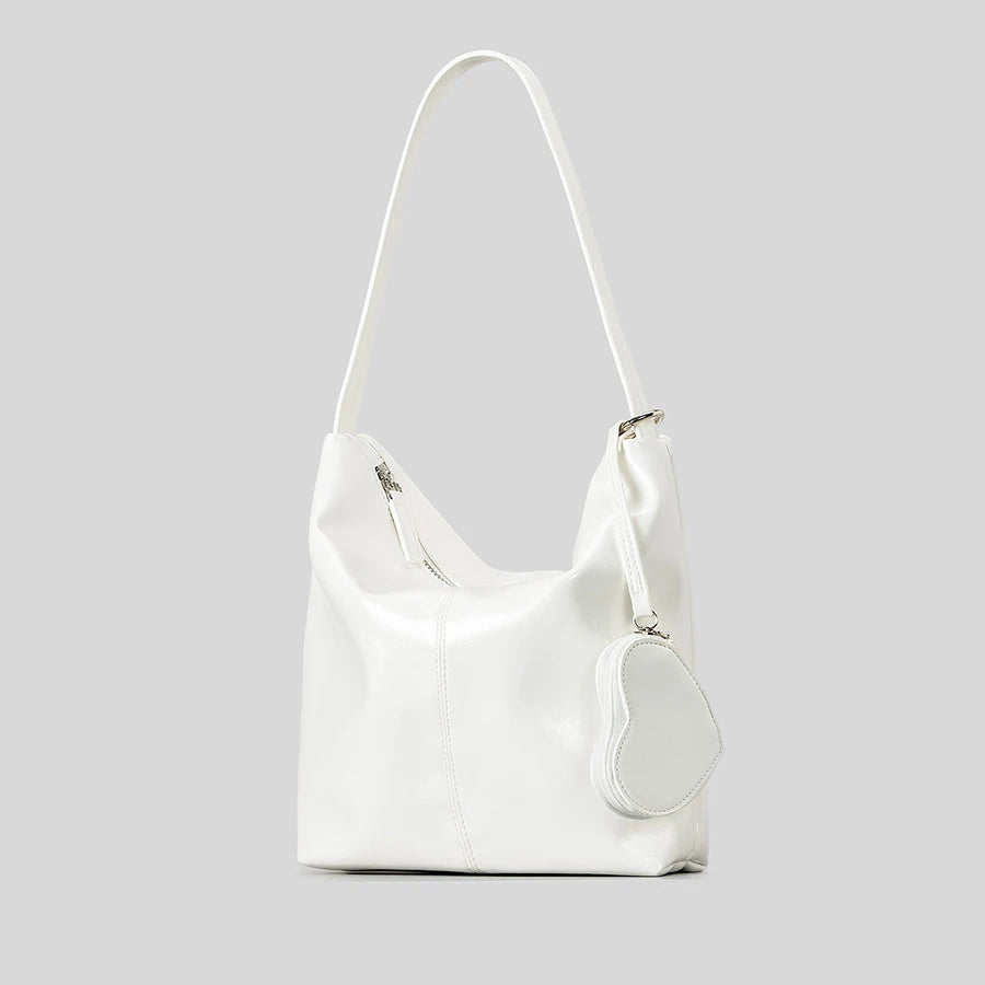 White shoulder bag with heart-shaped pouch, stylish accessory for casual outings