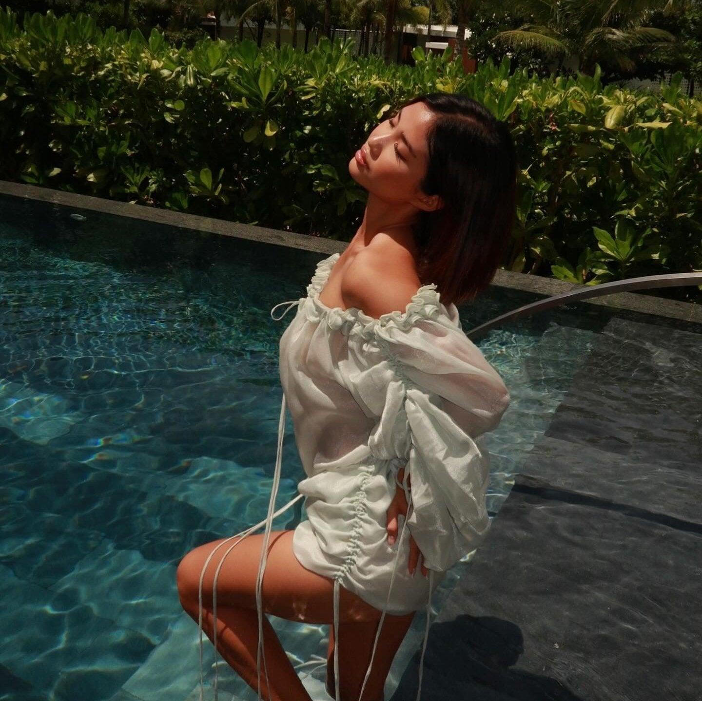 Light blue mini dress with off-the-shoulder design, ruched sleeves, and drawstring details, styled for a summer look.