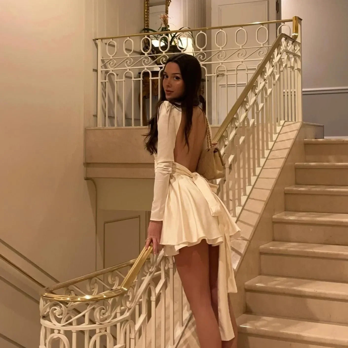 Backless satin mini dress with long sleeves and bow detail, elegant evening look