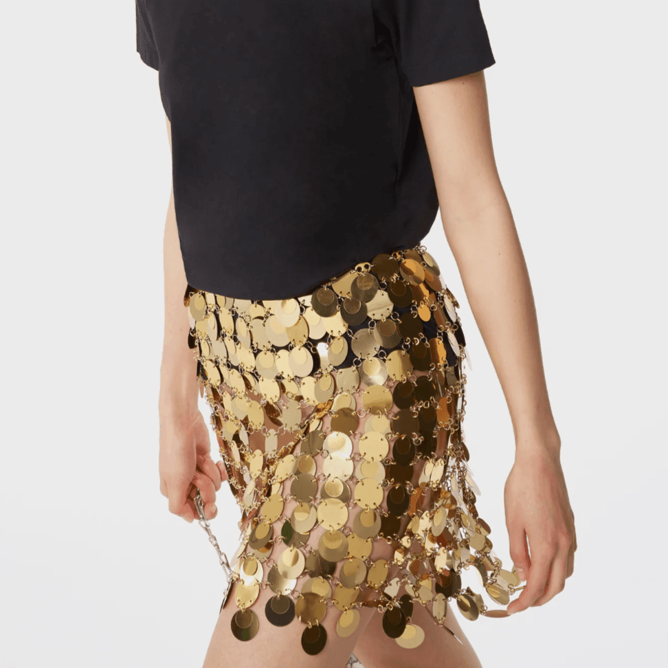 Gold sequin mini skirt with circular details, styled with a black t-shirt for a stylish, festive look.