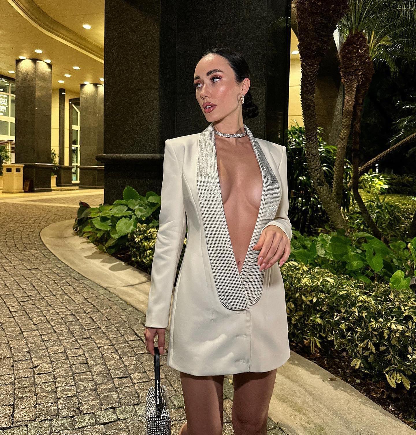 Cream blazer dress with deep neckline and rhinestone details, perfect for evening wear.