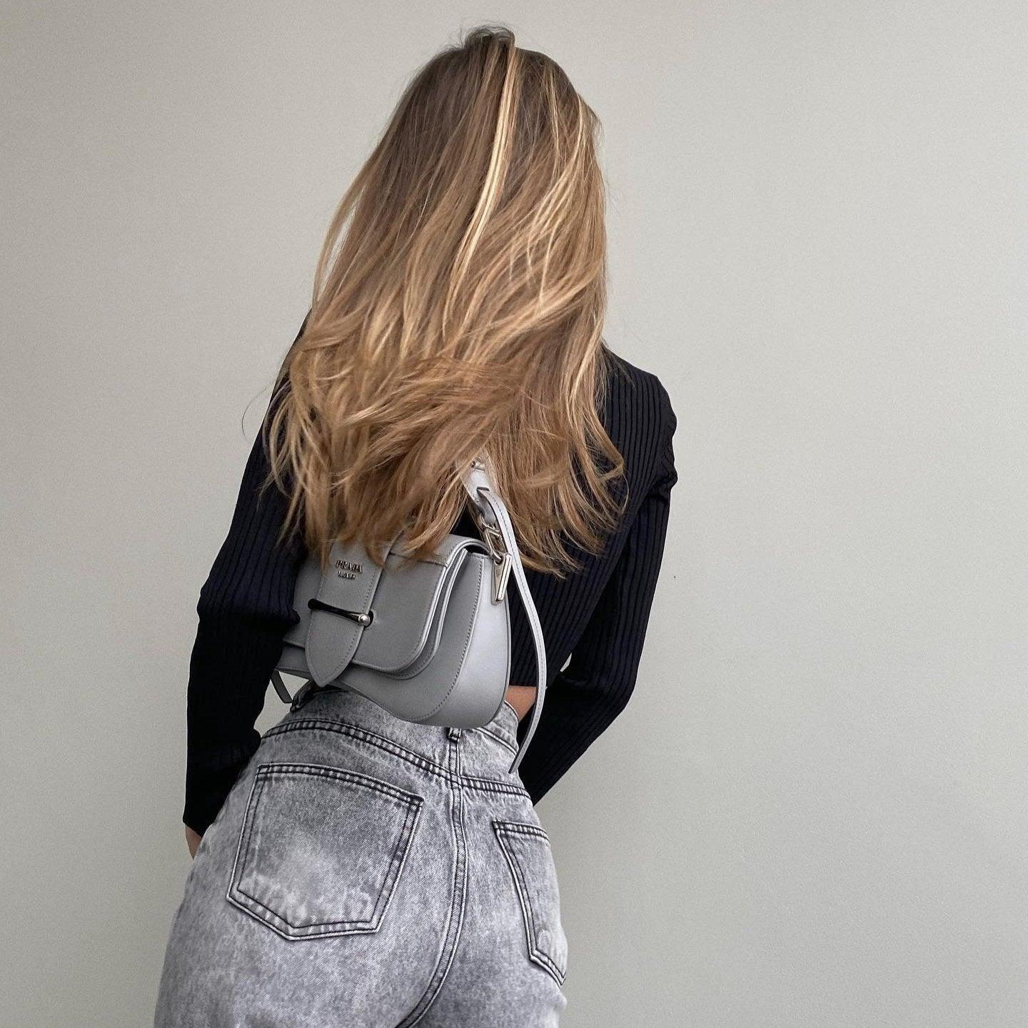 denim high-waisted jeans with black ribbed top, crossbody bag