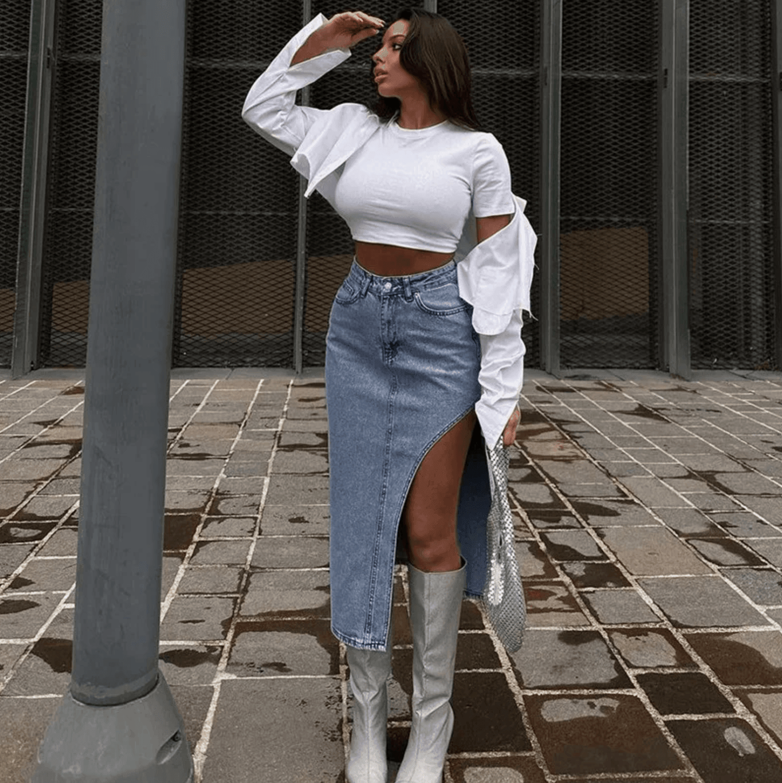 Ruffled long-sleeve crop top paired with high-slit denim skirt and knee-high boots, casual chic