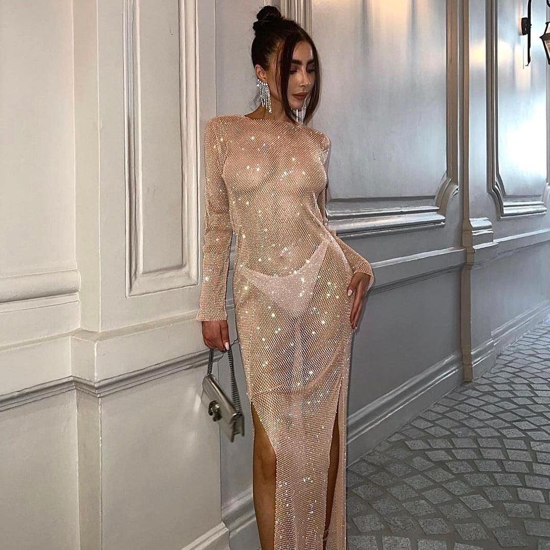 Beige rhinestone maxi dress with long sleeves and high slit, styled for an elegant evening look.
