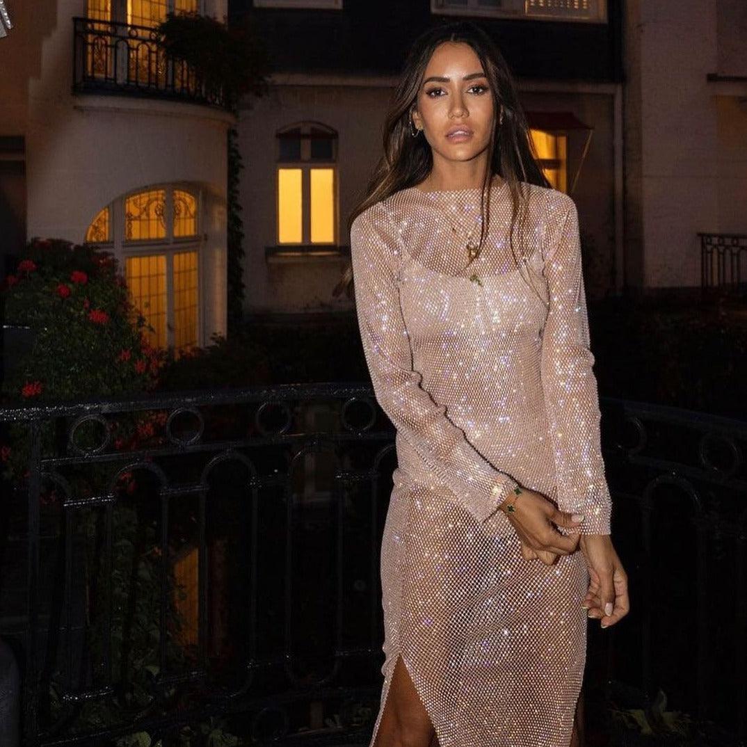 Beige rhinestone maxi dress featuring a fitted silhouette, long sleeves, and a side slit, perfect for evening wear.