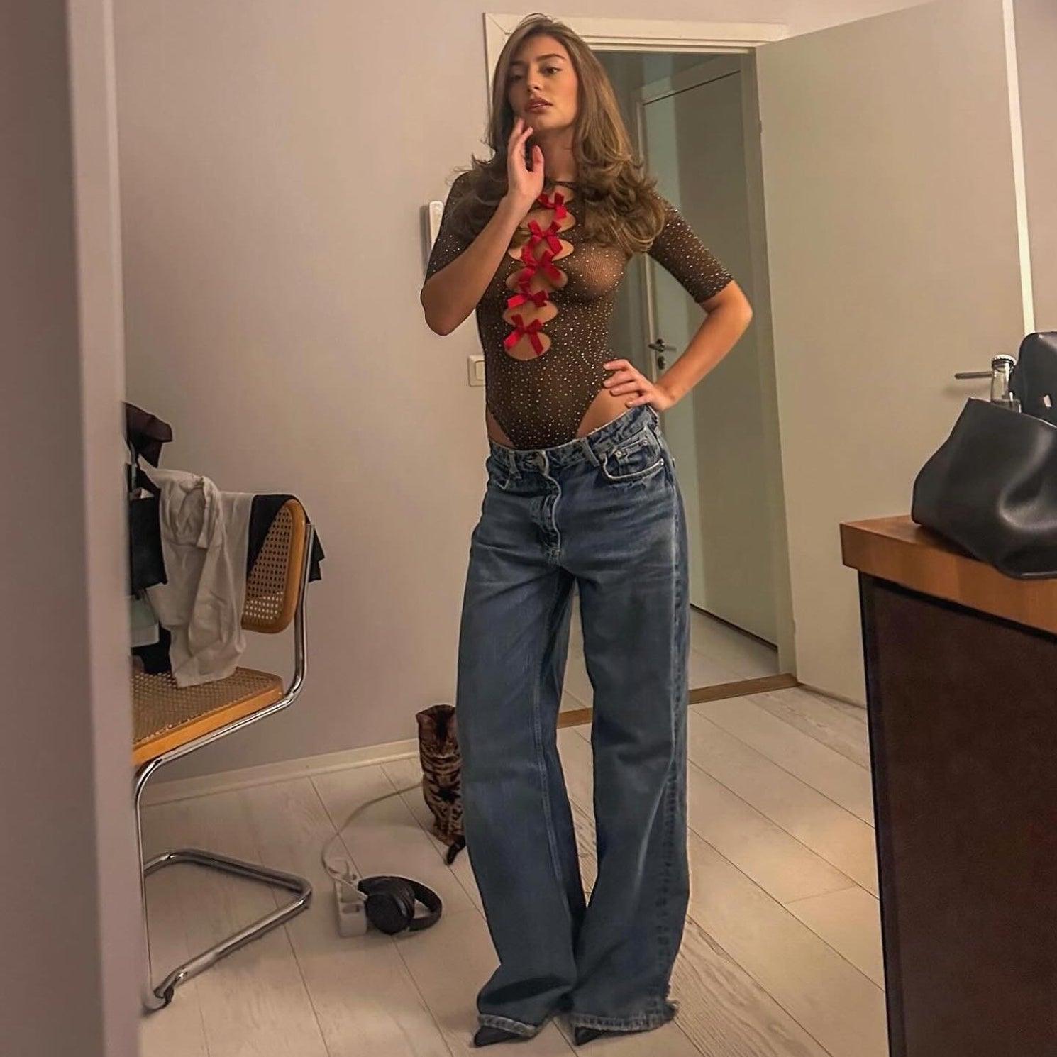 Sheer mesh top with red floral embellishment and high-waisted wide-leg jeans, casual evening look