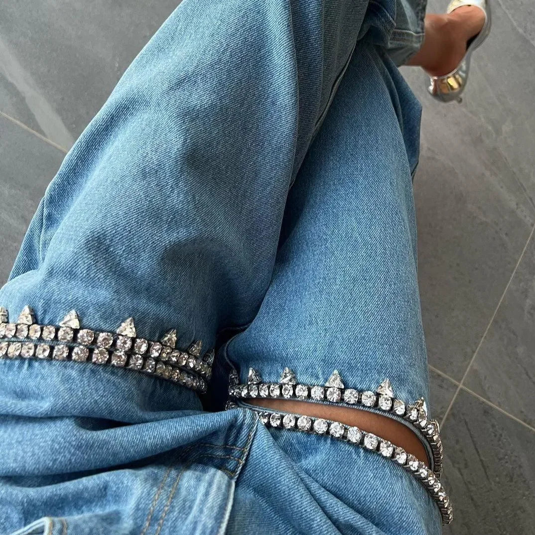 Denim jeans with rhinestone embellishments and cut-out details, stylish casual wear.