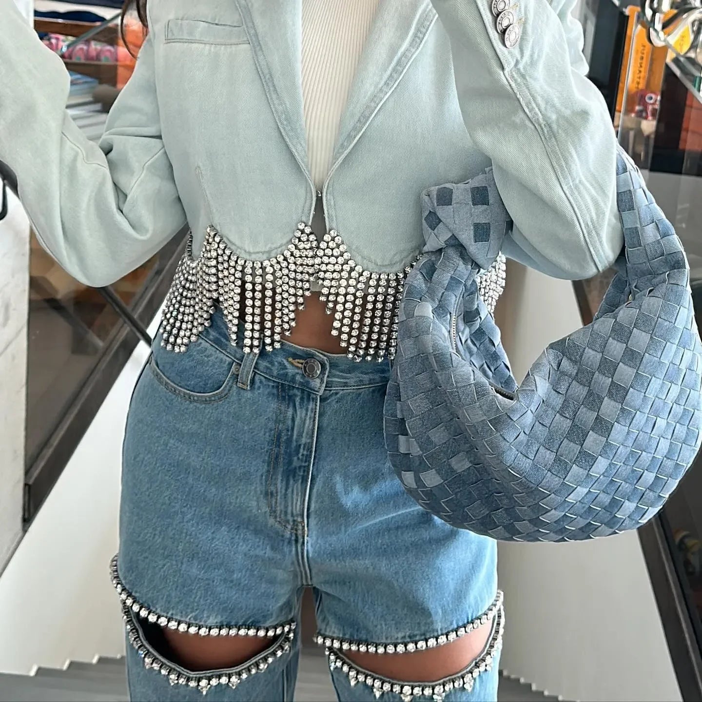 Cropped denim jacket with rhinestone fringe and embellished denim shorts, casual statement look.