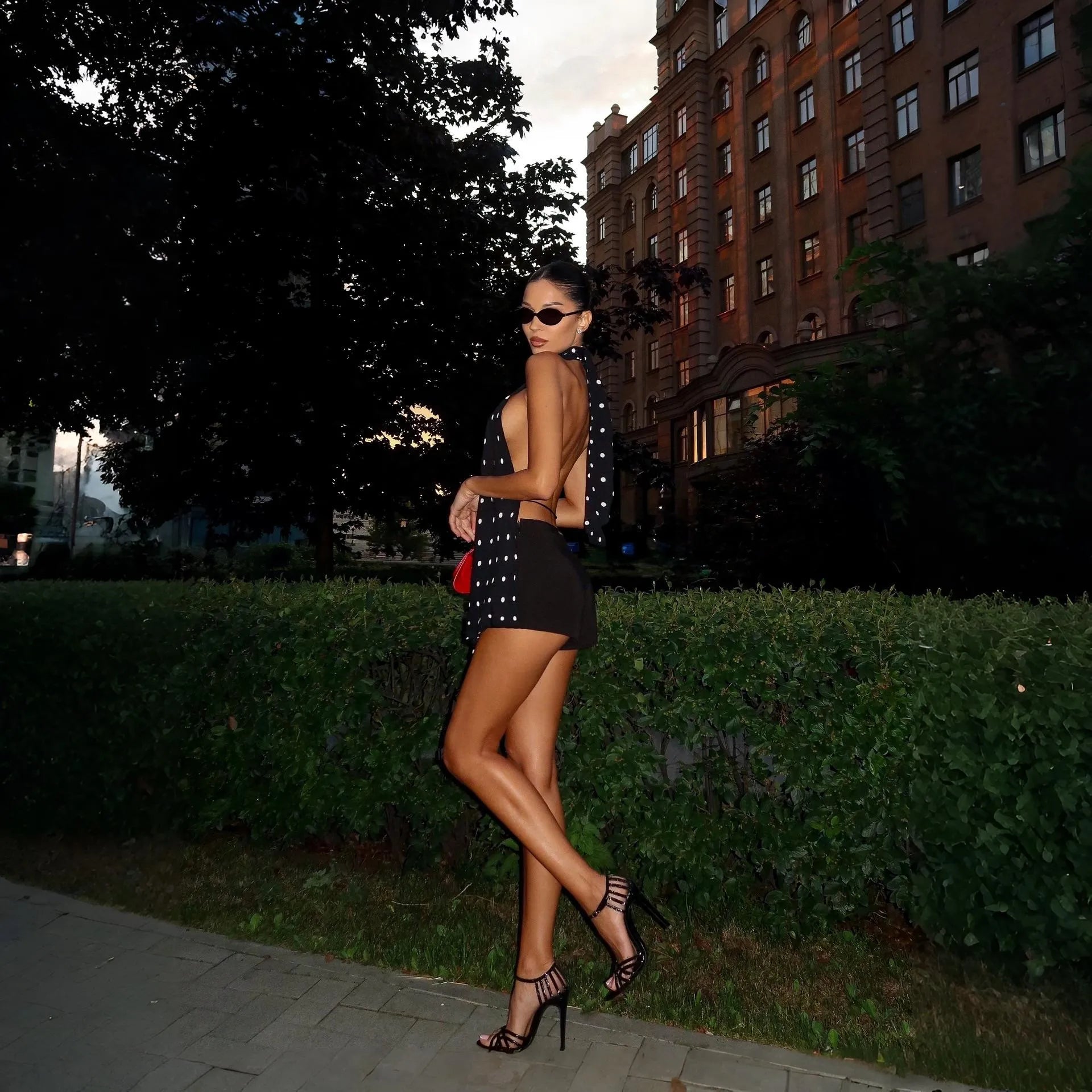 Backless polka dot halter top with high-waisted shorts, night-out look.