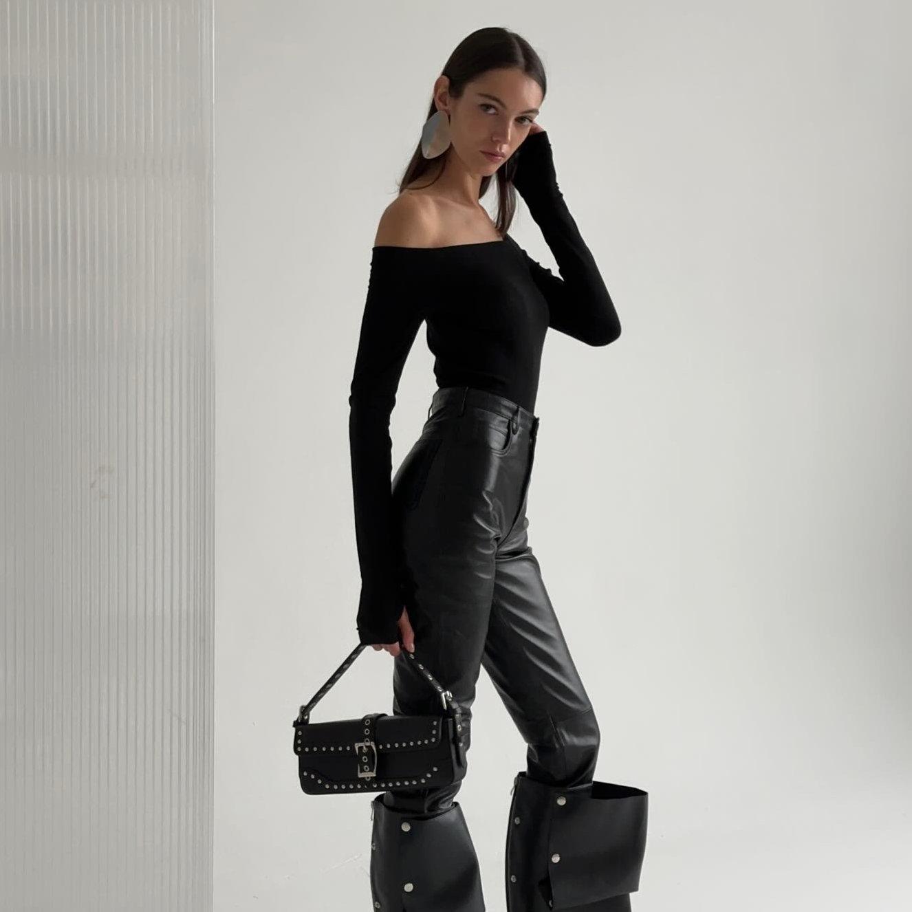 Off-the-shoulder long sleeve top with leather pants, chic evening outfit ensemble.
