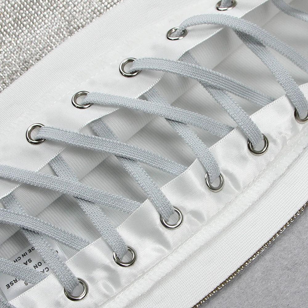 Lace-up satin detail, part of a corset-style outfit.