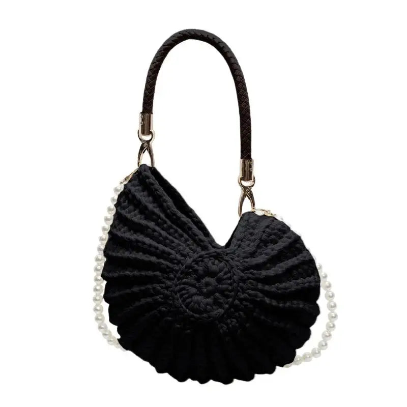 Black seashell-shaped bag with pearl accents.