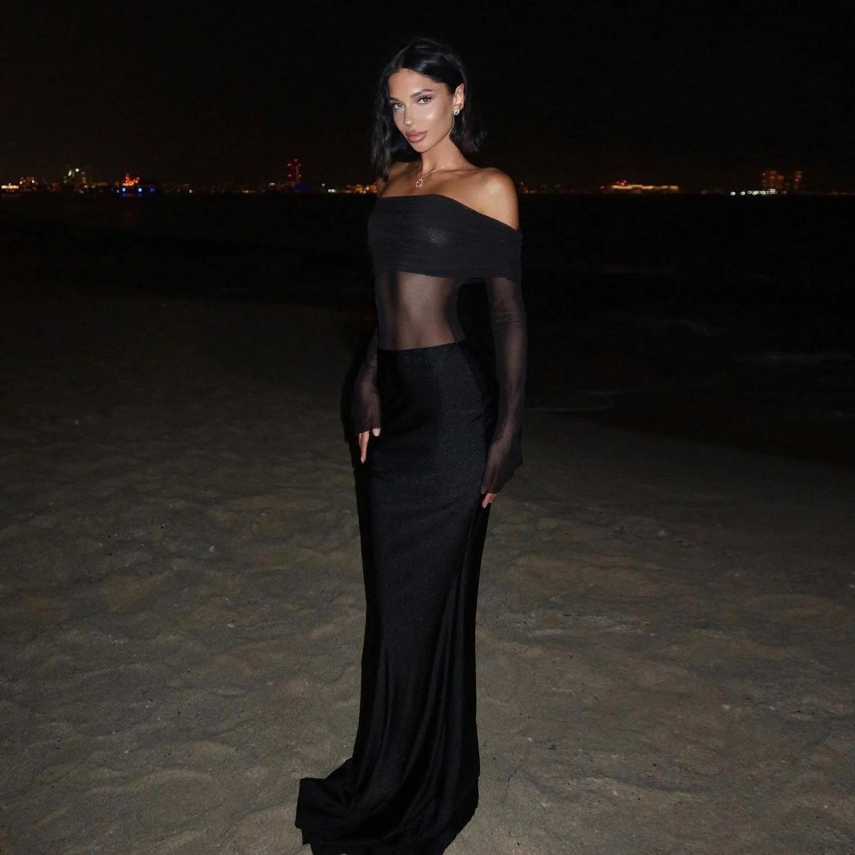 Sheer mesh off-shoulder long black dress, elegant evening look.