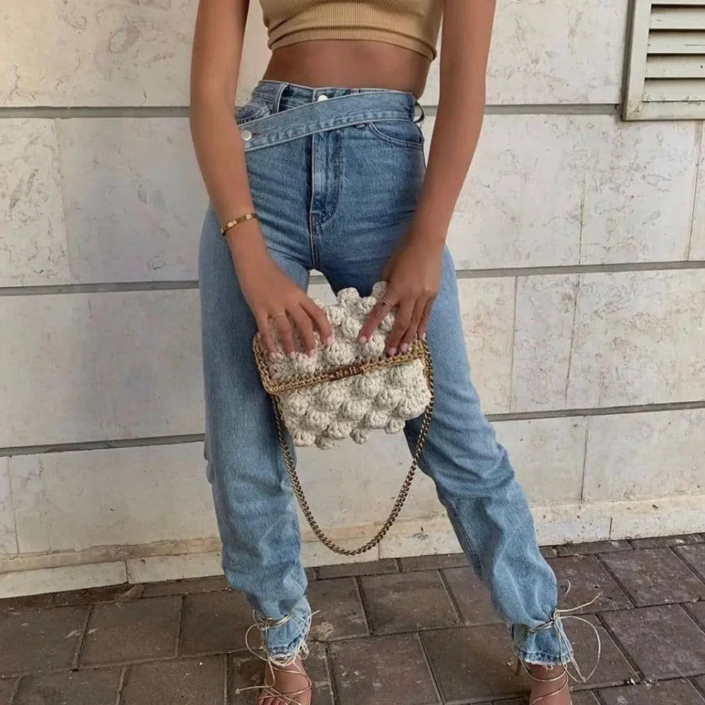 Ribbed crop top with high-waisted jeans and textured clutch, casual daywear styling