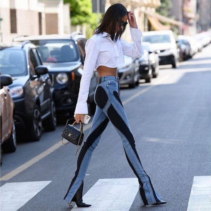 Cropped white blouse with high-waisted patchwork jeans, chic street style outfit.