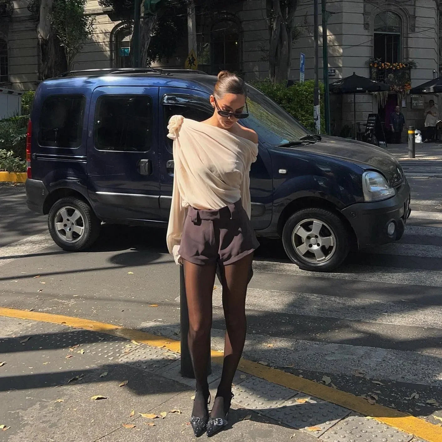 Off-shoulder sheer top with statement sleeves and tailored shorts, chic city style