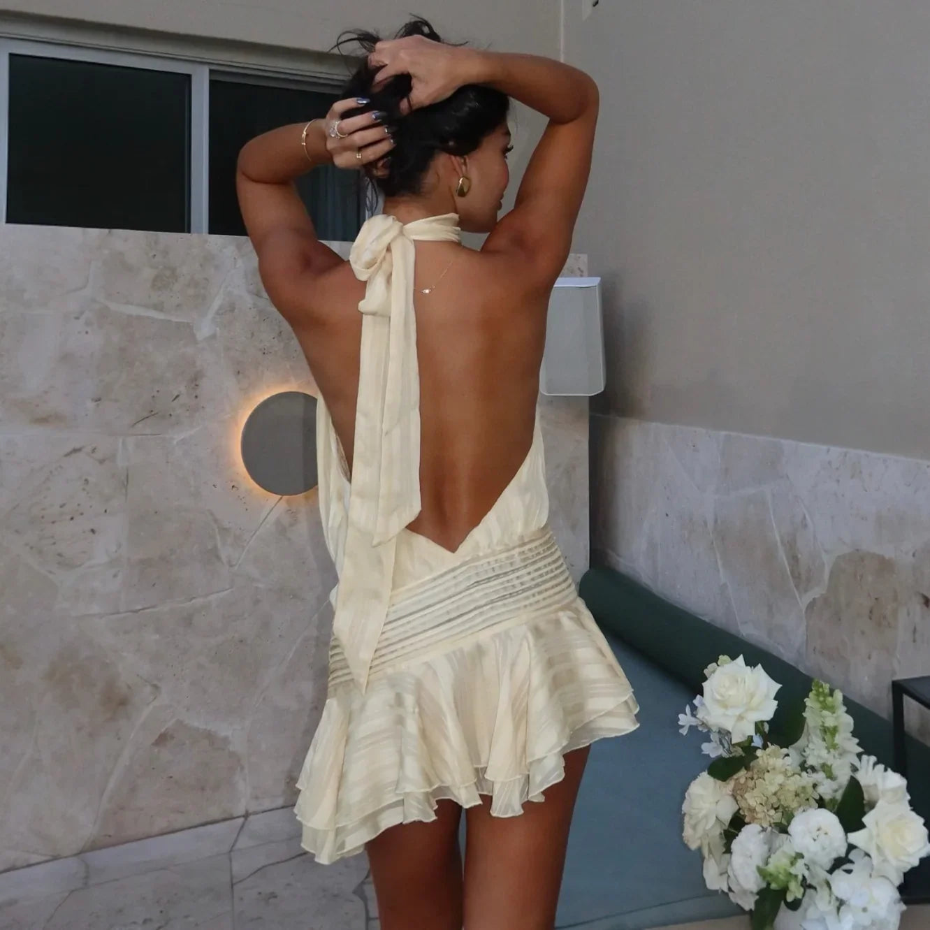 Backless tie-up halter mini dress with ruffled hem, elegant evening look.