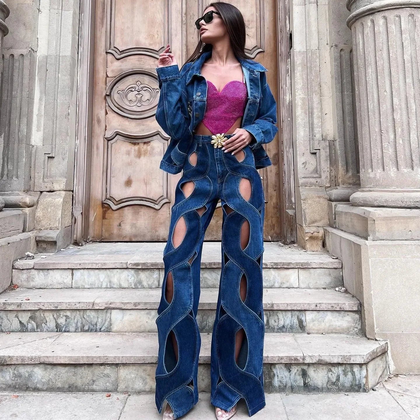 Denim jacket with matching cut-out jeans and pink embellished tube top, trendy statement look.