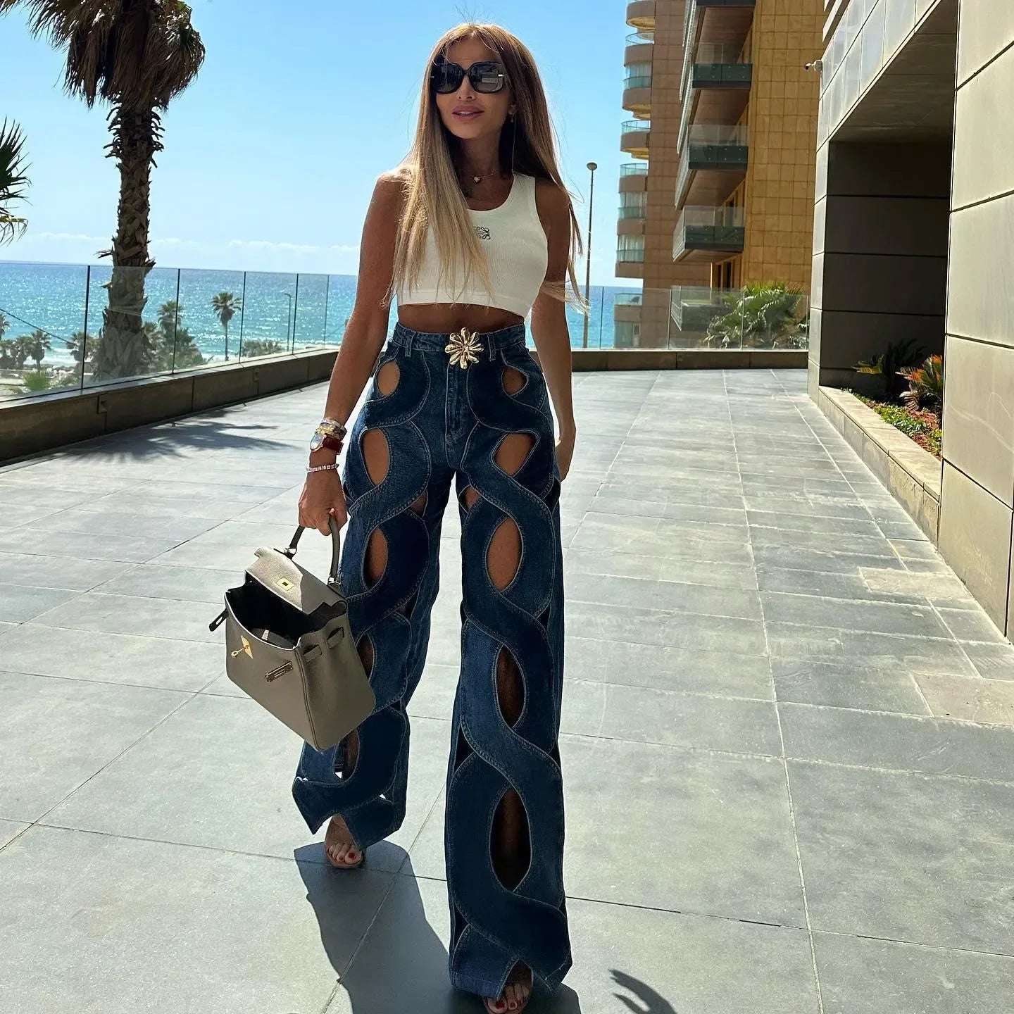 Wide-leg cutout denim jeans paired with a white sleeveless crop top, casual daytime style.