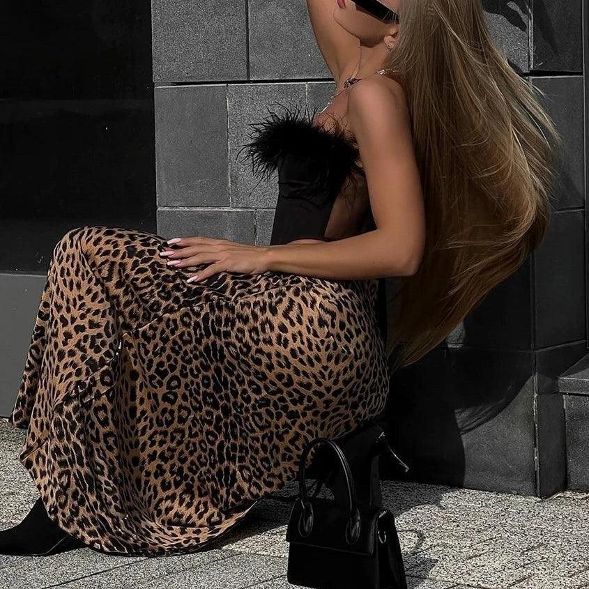Feather-trimmed corset top with leopard print maxi skirt, chic night-out ensemble.