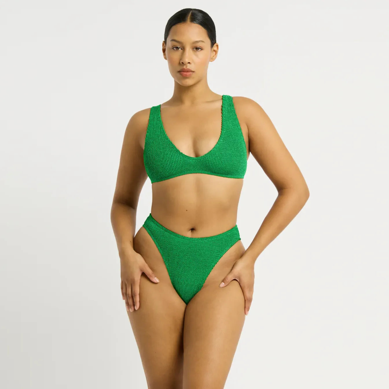 Green textured bikini set with scoop neck top and high-waisted bottoms, beachwear style.