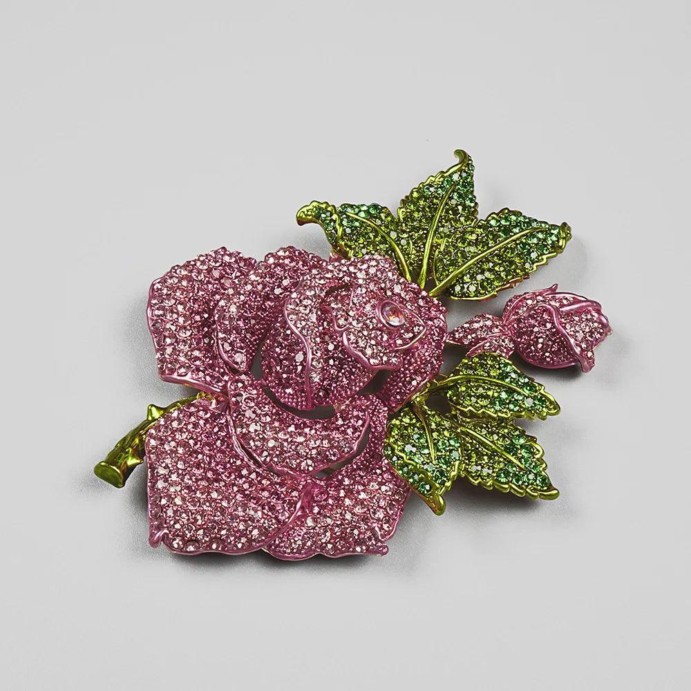 Floral rhinestone brooch with pink rose and green leaves, statement accessory piece.