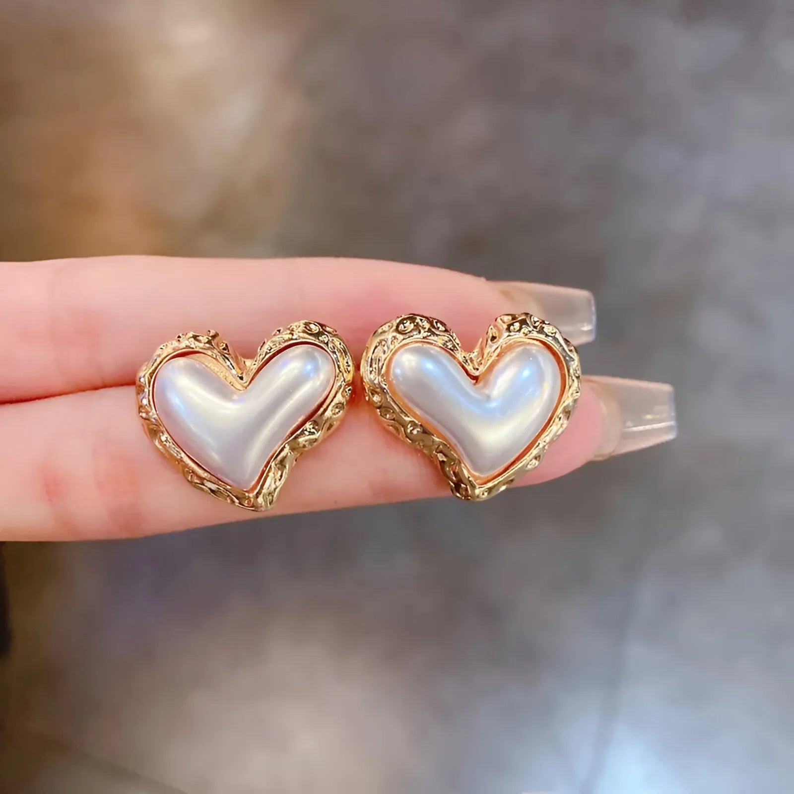 Heart-shaped pearl and gold earrings.