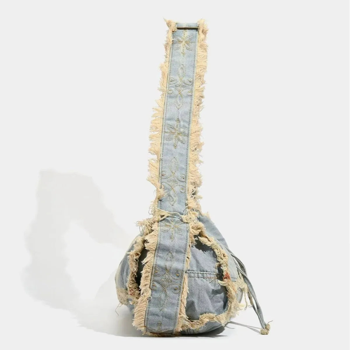 Distressed denim shoulder bag with frayed edges, casual accessory.
