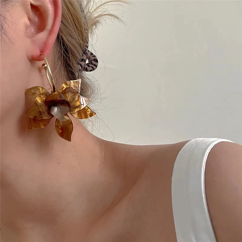 Golden floral hoop earrings, statement accessory.