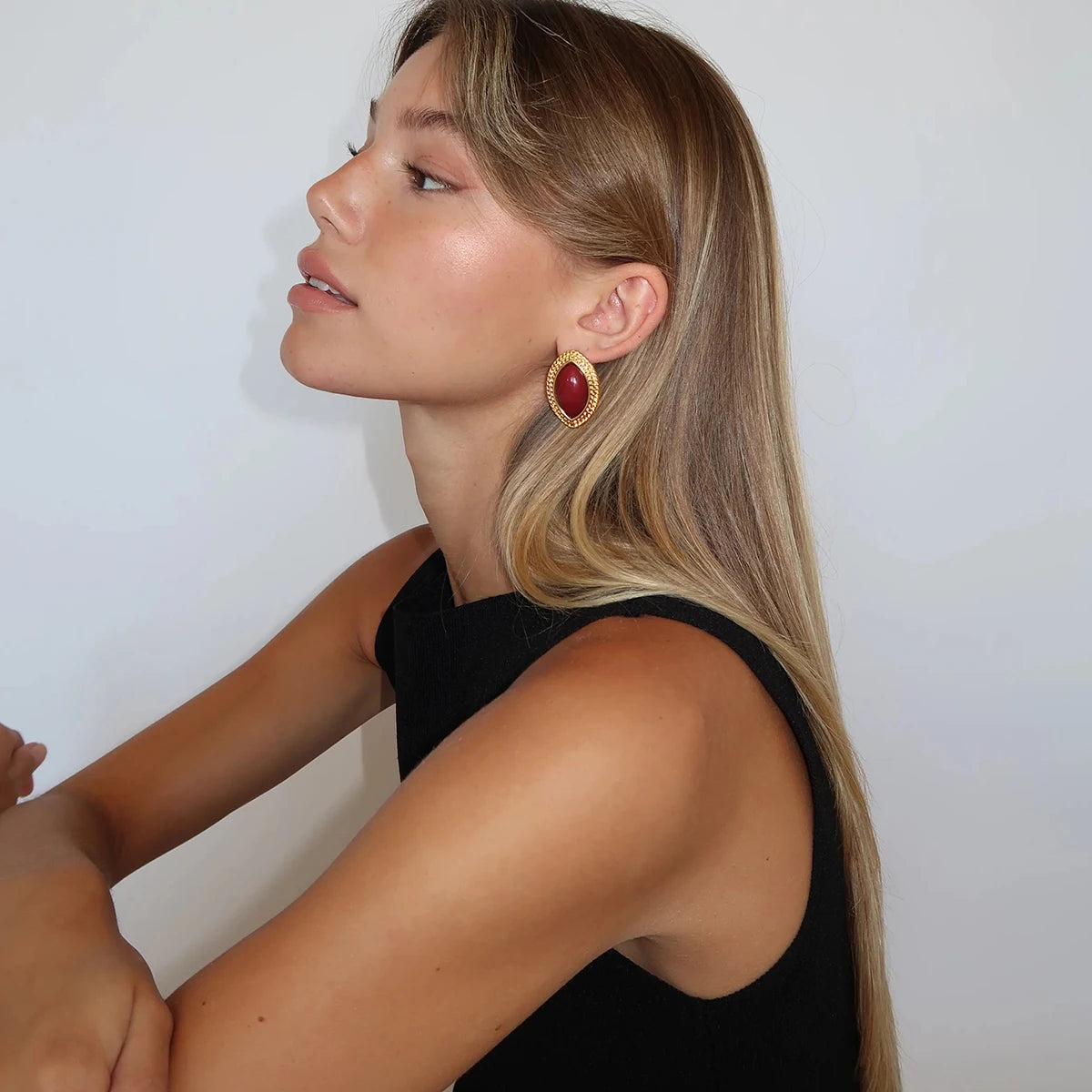 Gold-framed red oval drop earrings, statement accessory.