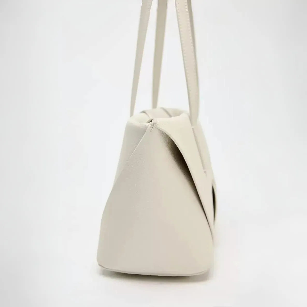 Cream leather handbag with structured design, versatile accessory.