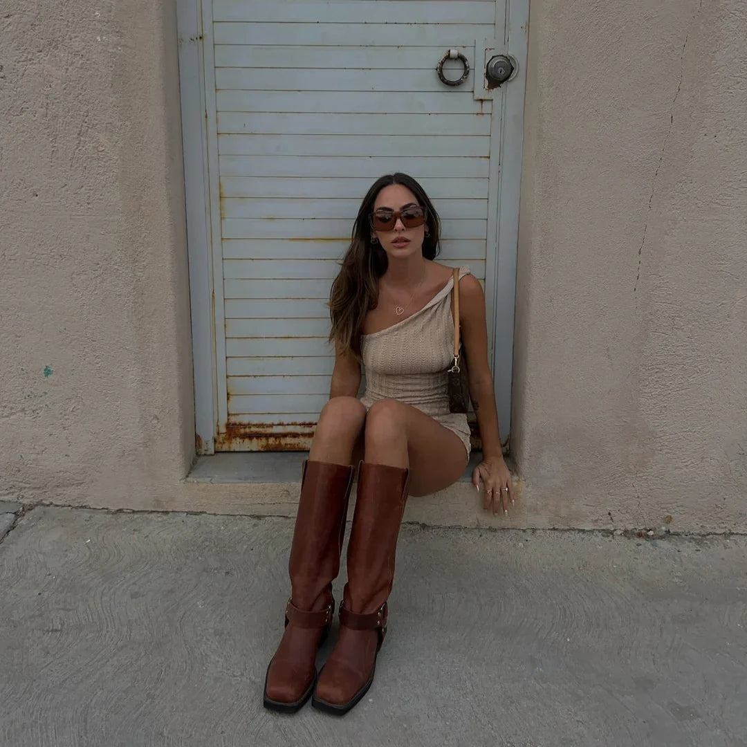 One-shoulder knit mini dress with casual daytime style, paired with knee-high leather boots.