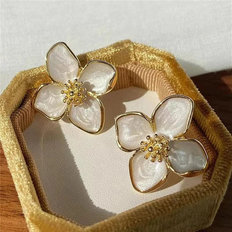 Gold floral earrings with pearl-like petals, elegant accessory