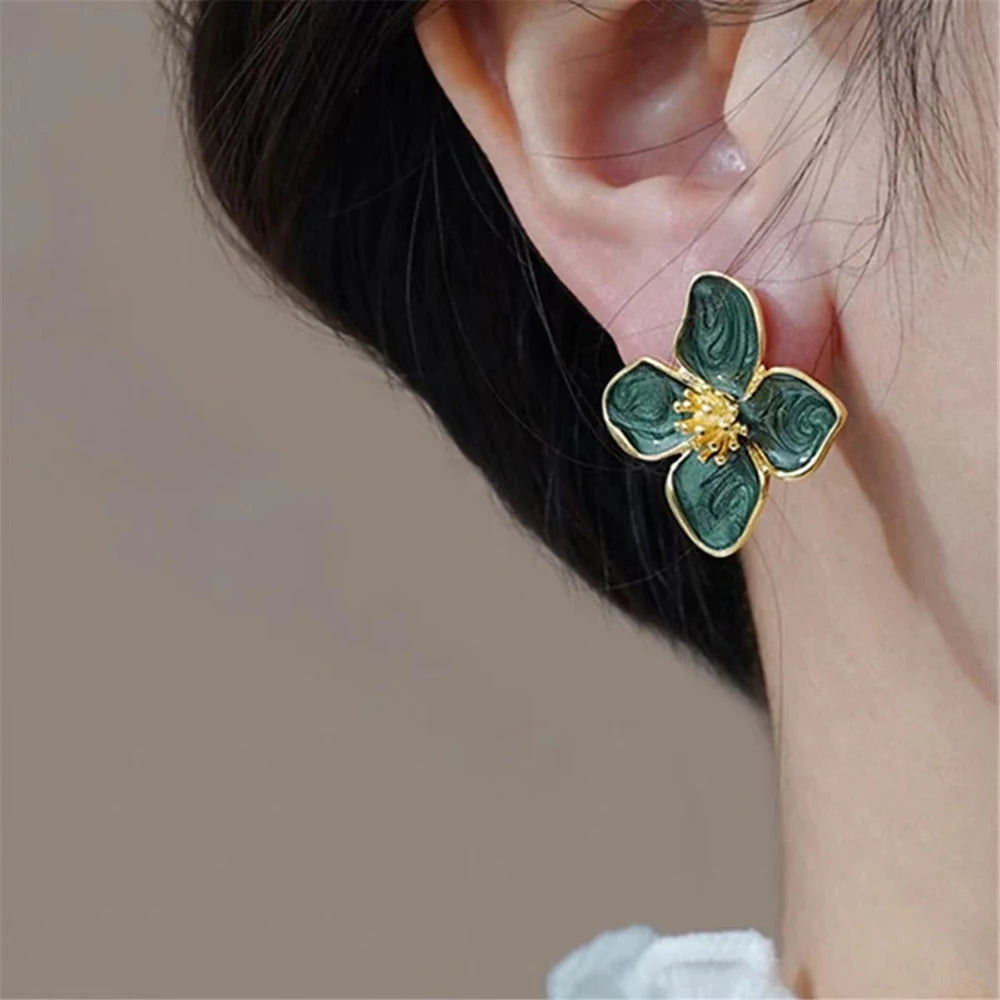 Floral stud earring with green petals and gold detailing, elegant accessory.