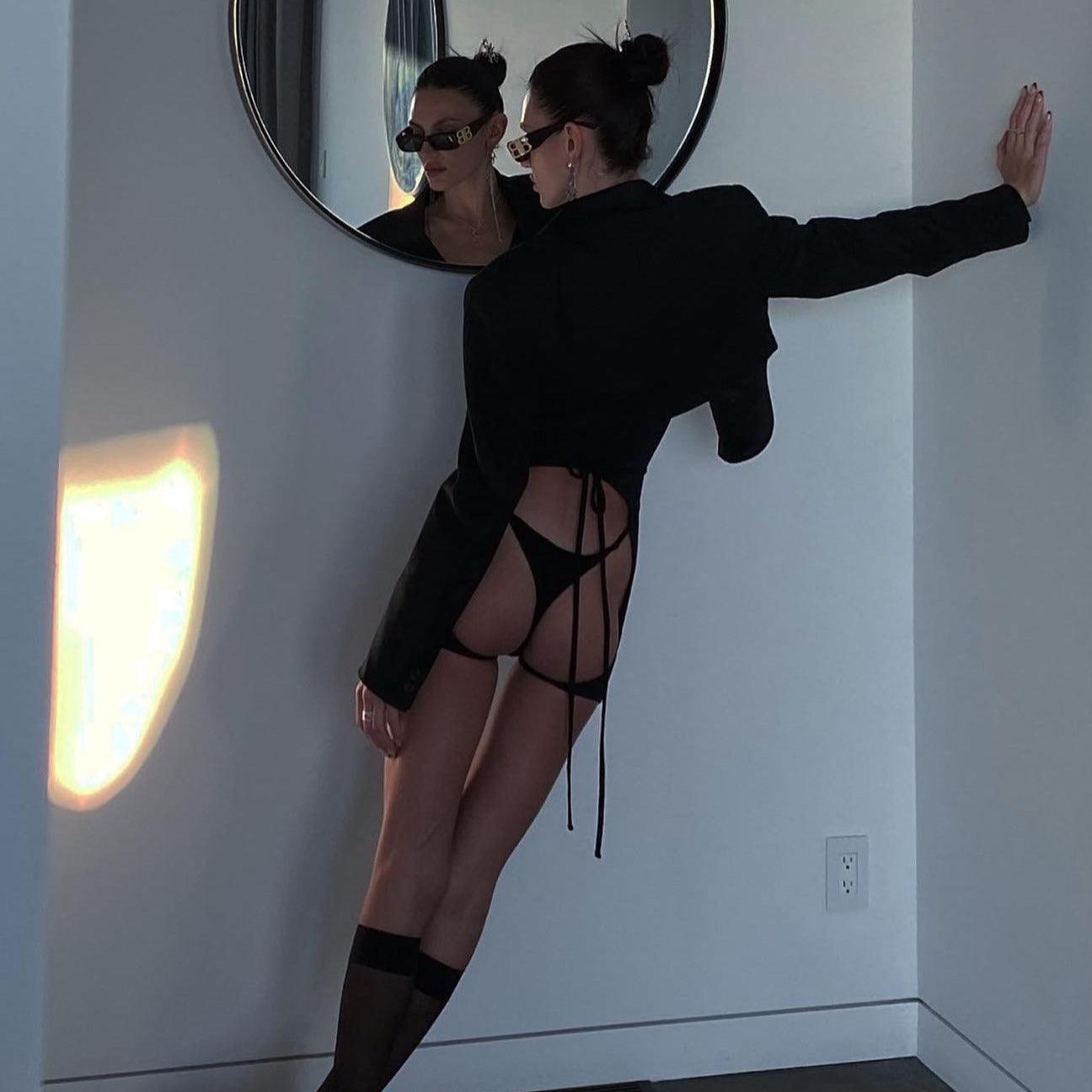 black cropped blazer with tie-back, paired with high-cut bikini bottoms, modern party outfit