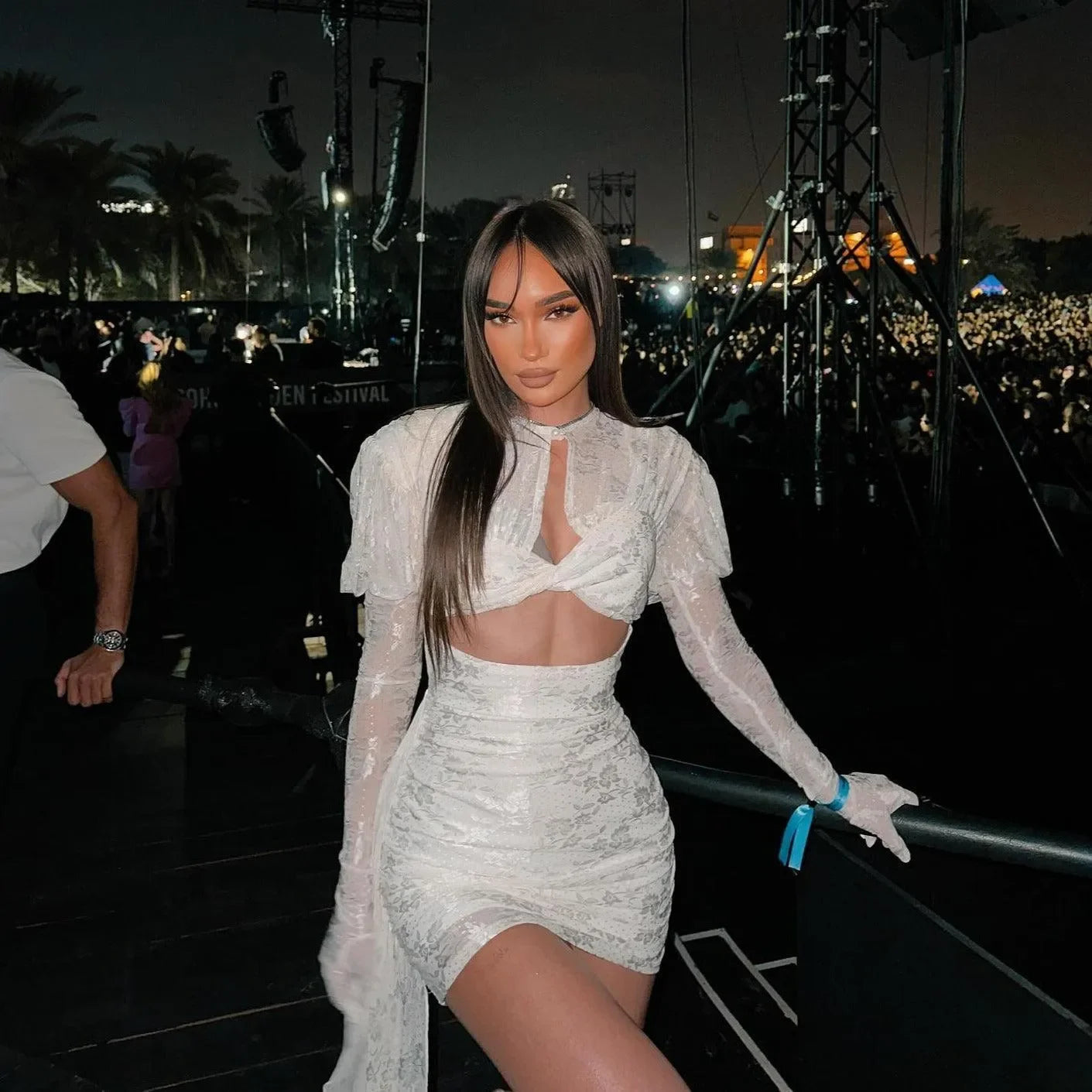 Draped white mini dress with gloves, featuring a cut-out front and puff sleeves, styled for a night out.