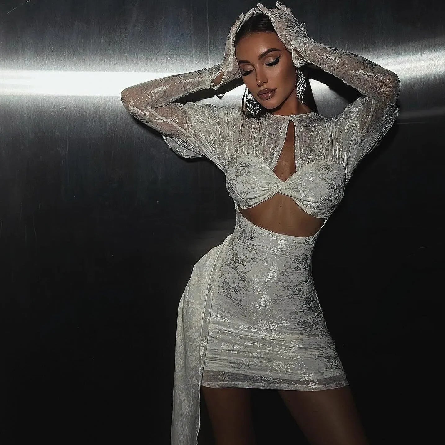 White mini dress featuring draped detailing, cut-out sides, and coordinating long gloves for a stunning evening look.