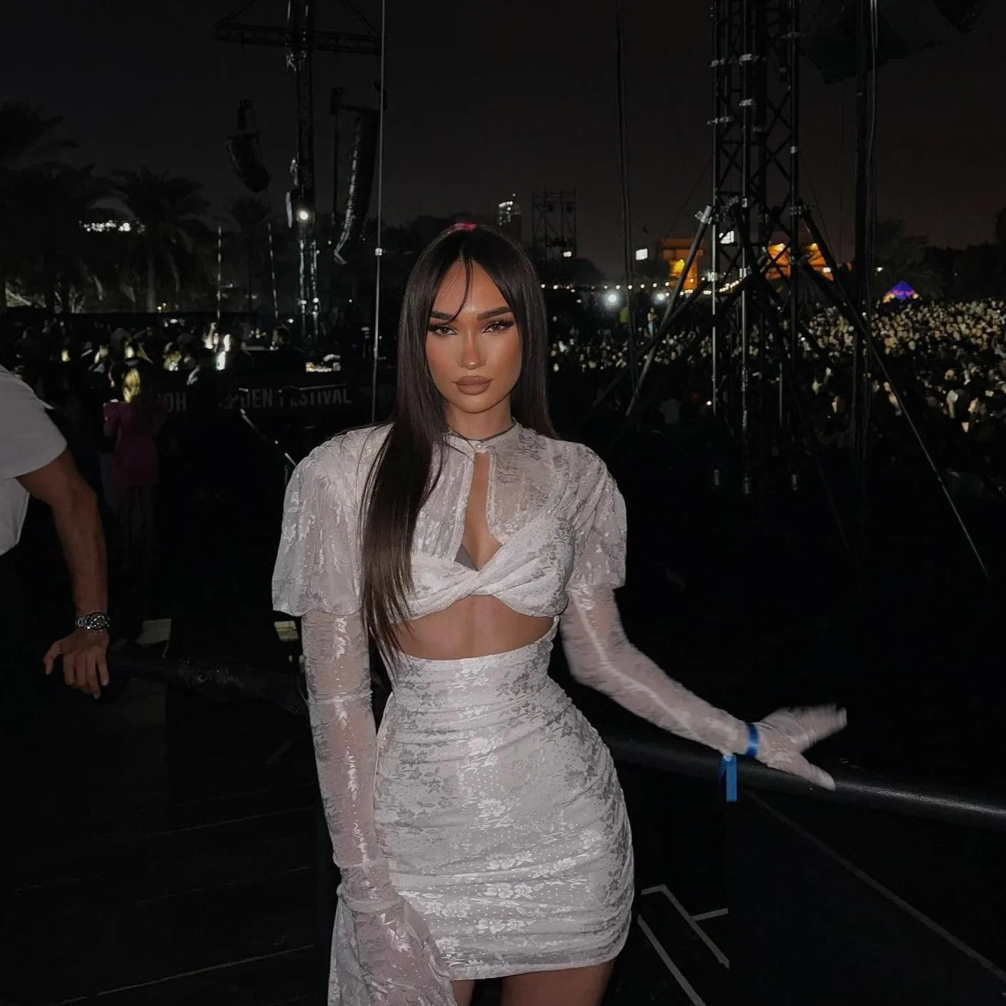 White mini dress with draped detailing, long gloves, styled with a cut-out bodice for a chic, bold look. Perfect for...