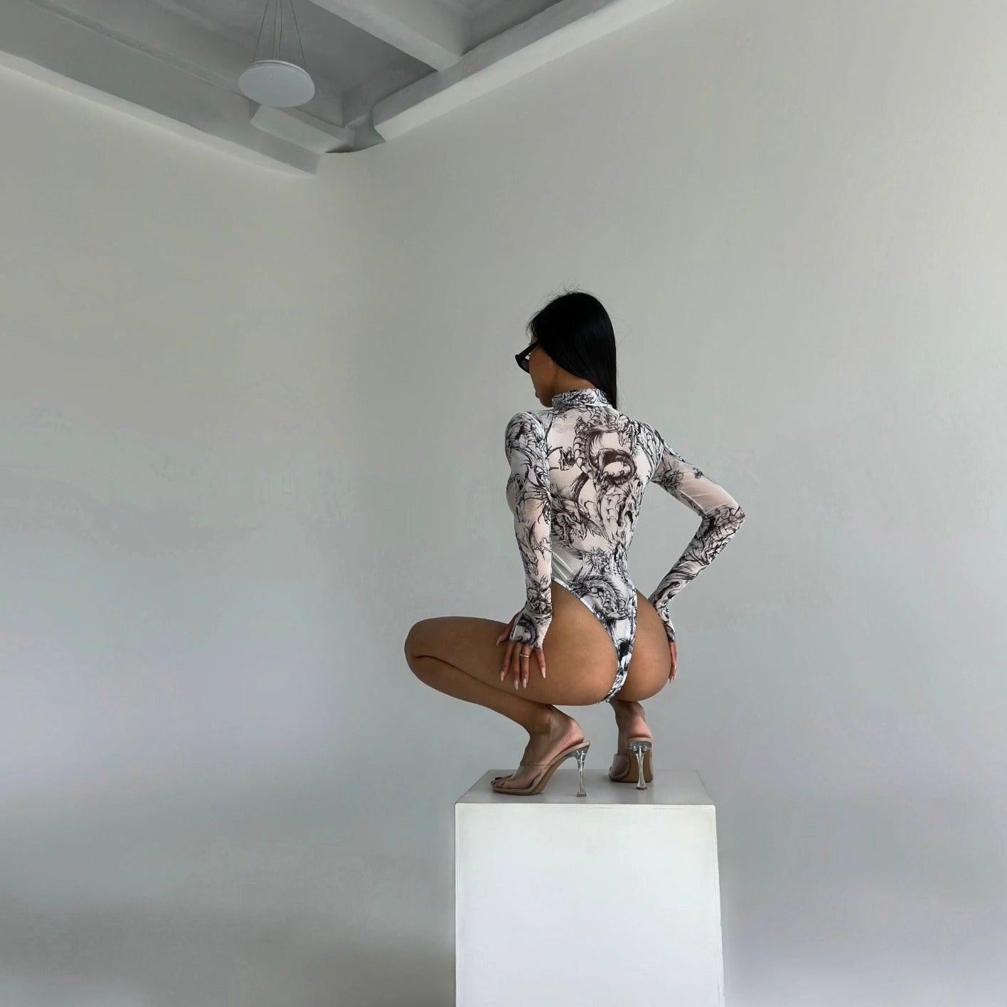 printed mesh bodysuit with long sleeves, paired with clear heels