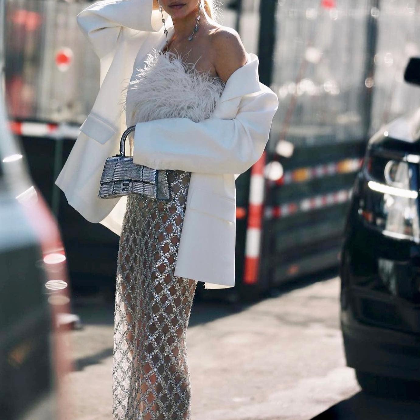 Feather-adorned dress with sheer metallic skirt and white blazer.