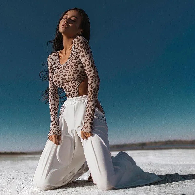 Leopard print bodysuit with cut-outs paired with white wide-leg pants.